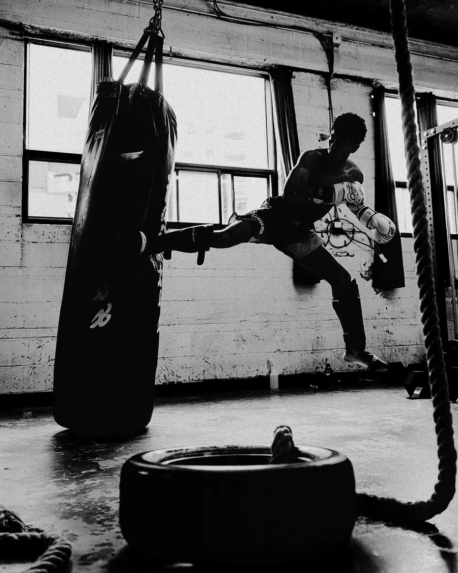 Fighter mid-kick against a heavy bag