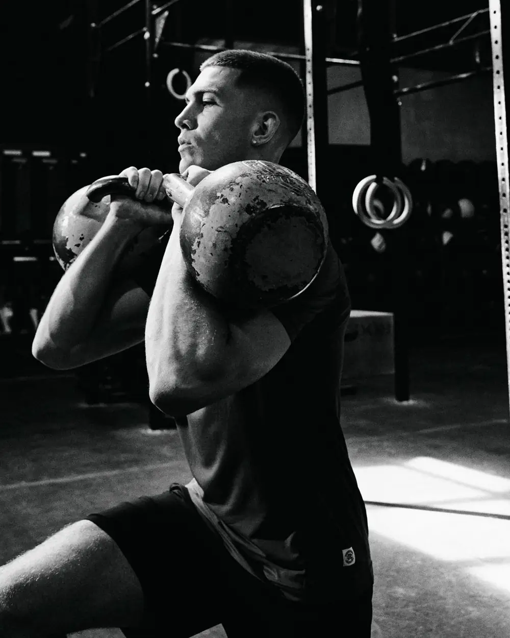 Front rack kettlebell hold in a dark gym